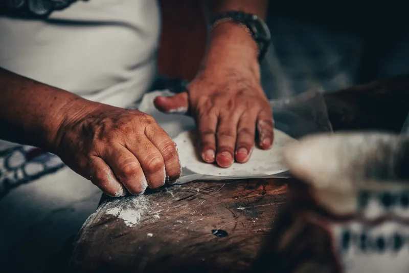 Excellent process image of anonymous hands shaping a tortilla