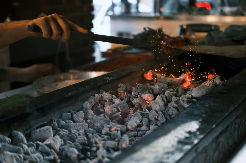 Active charcoal cooking with anonymous hands and sparks
