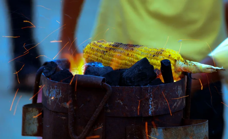 Grilled corn over charcoal strongly connects the fire and corn parts of the identity
