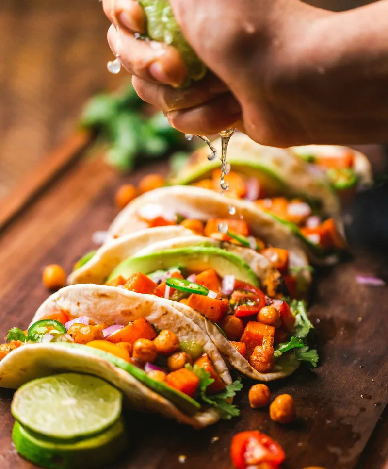Useful vertical food feature with an anonymous hand adding lime