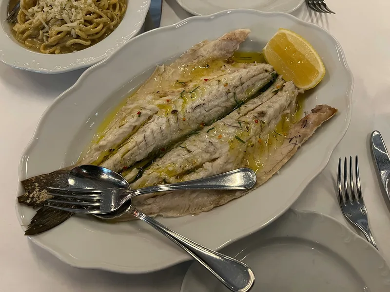 Restrained whole-fish plate with strong central composition and clear coastal identity